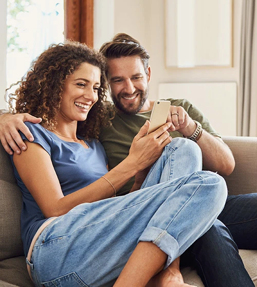 A couple happily looking at a phone