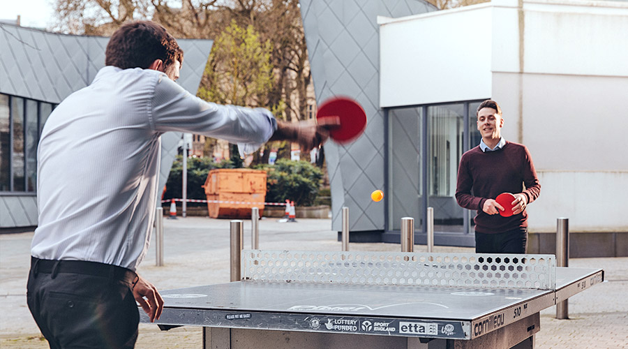 Two HL workers playing table tennis