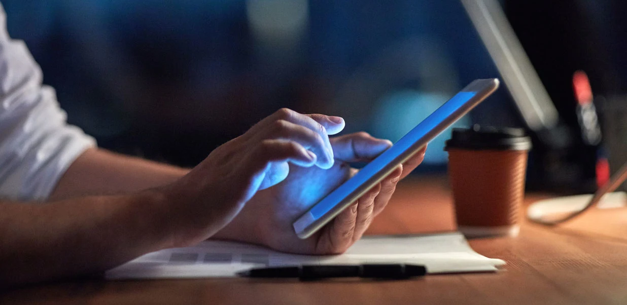 Man checking tablet at night