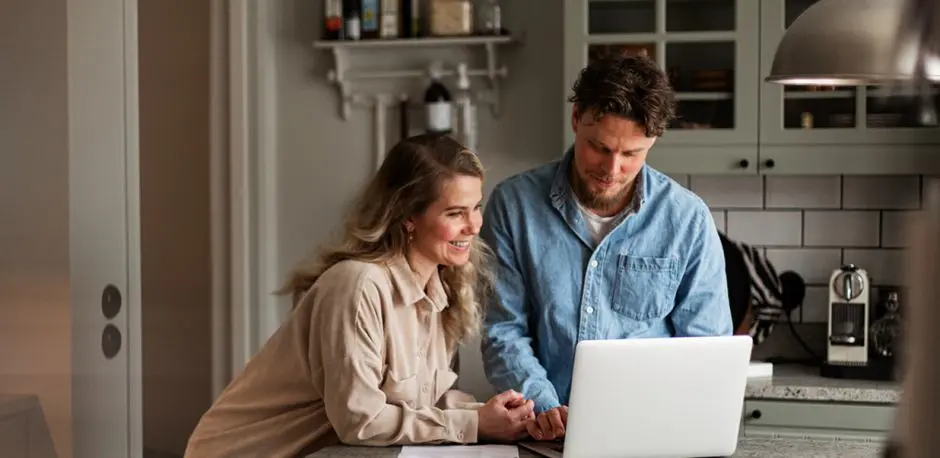 Couple looking at laptop in a kitchen