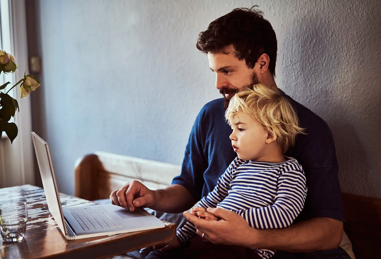 A son and father looking at a laptop