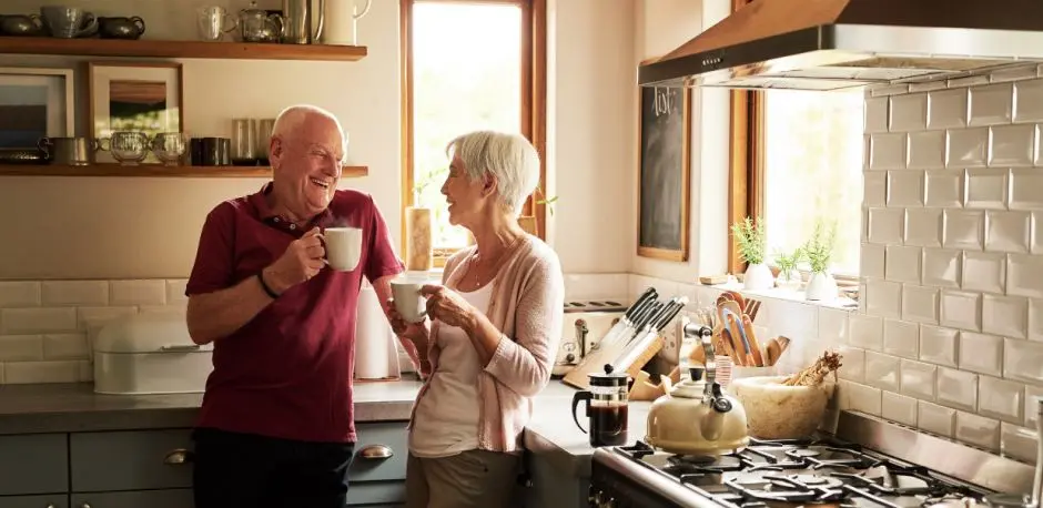 Older couple laughing in kitchen
