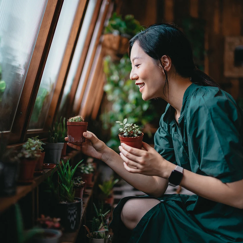 Lady stood in kitchen smiling, eating toast and drinking coffee