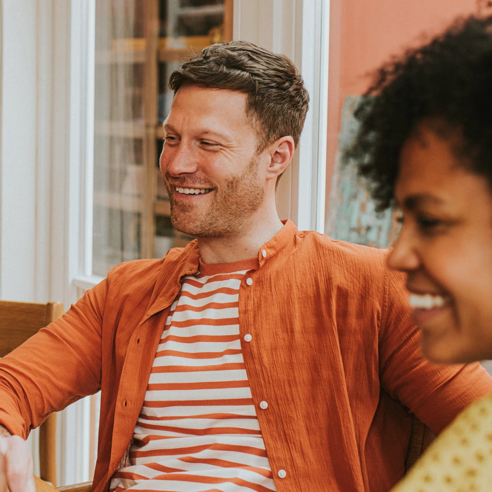 Man in focus smiling and woman in soft focus also smiling