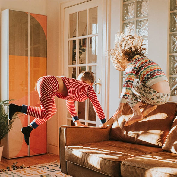 Children jumping on a sofa