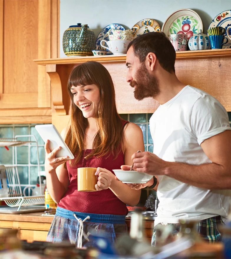 Young couple looking at a tablet smiling