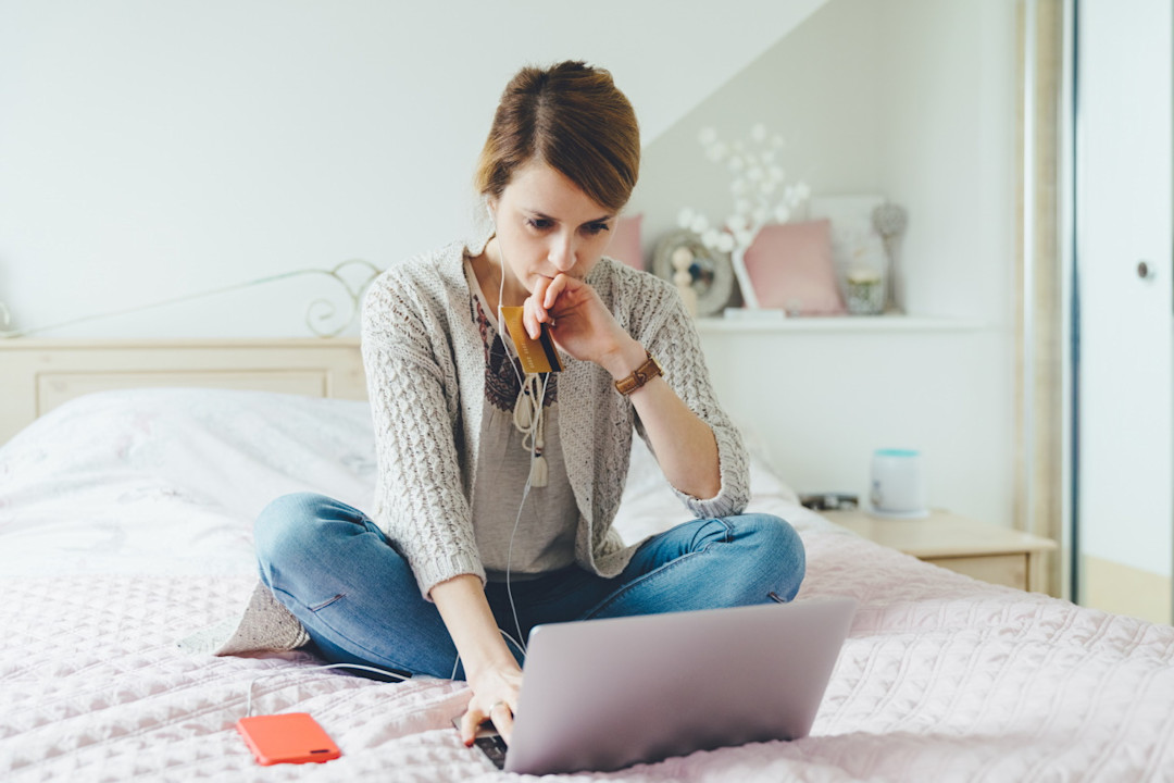 Woman sitting on bed looking worried about investing.jpg