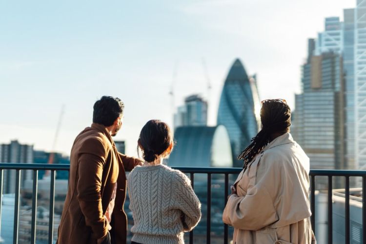 Three people on a bridge looking over at Central London.jpg
