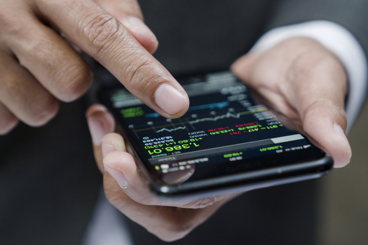 Businessman using a mobile phone to check stock market data.jpg