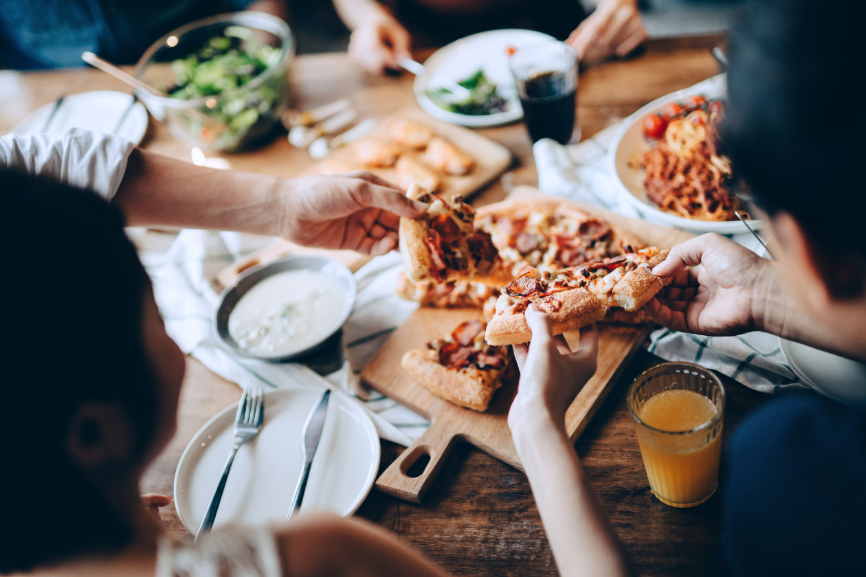 Young group of friends passing and serving food-GettyImages