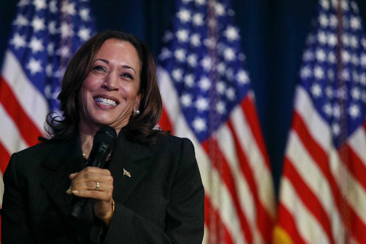Kamala Harris smiling in front of the US flag.jpg