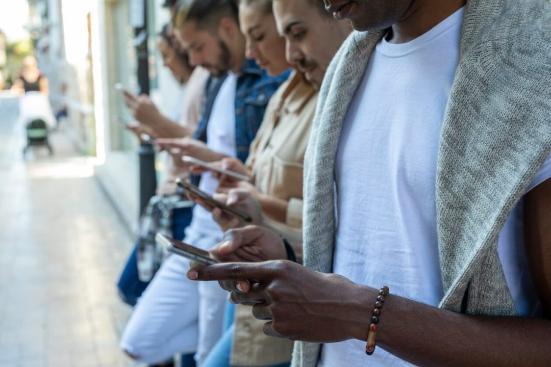 People standing in a line looking at smart phones.jpg