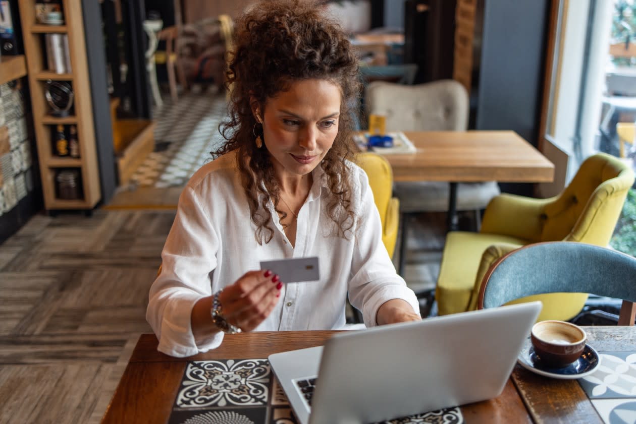 Woman online shopping on laptop in a restaurant space.jpg