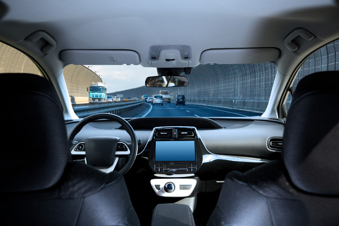 Cockpit of driverless car driving on highway viewed from rear seat.jpg