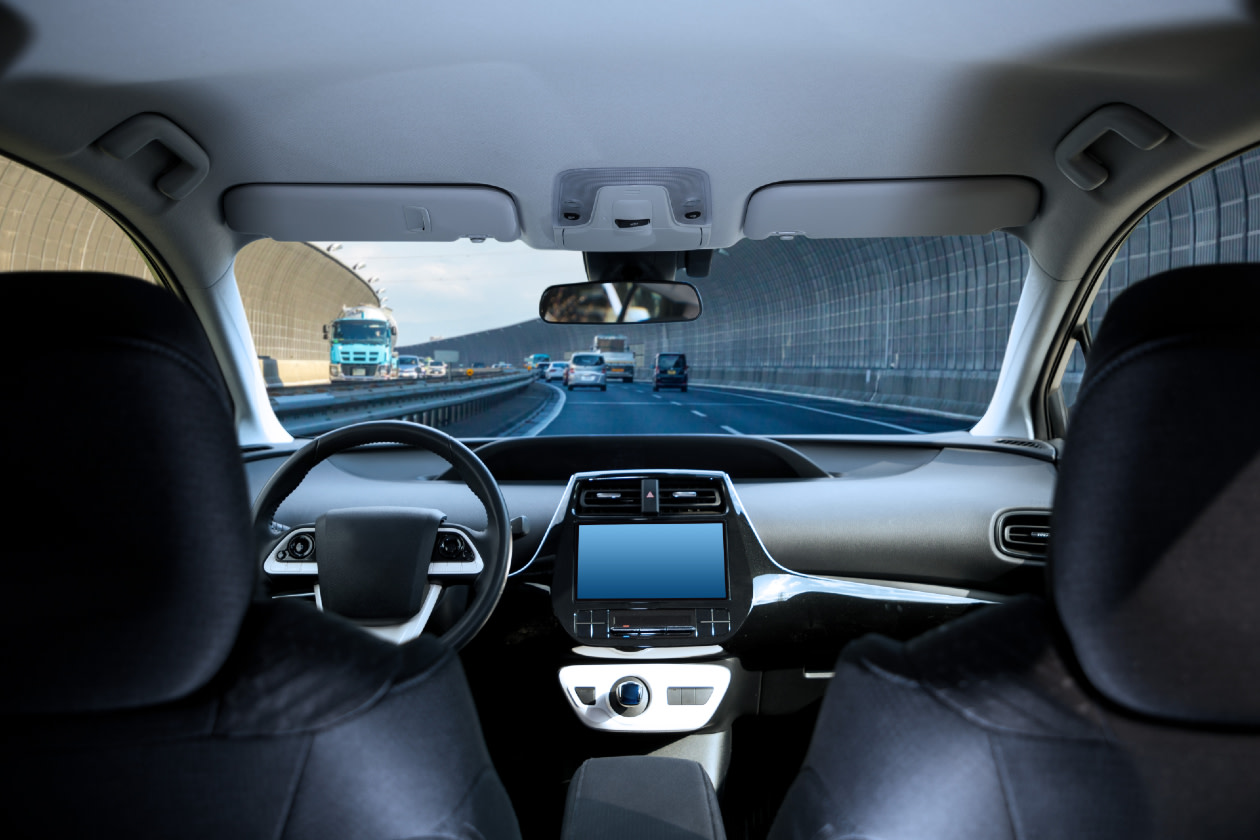 Cockpit of driverless car driving on highway viewed from rear seat.jpg