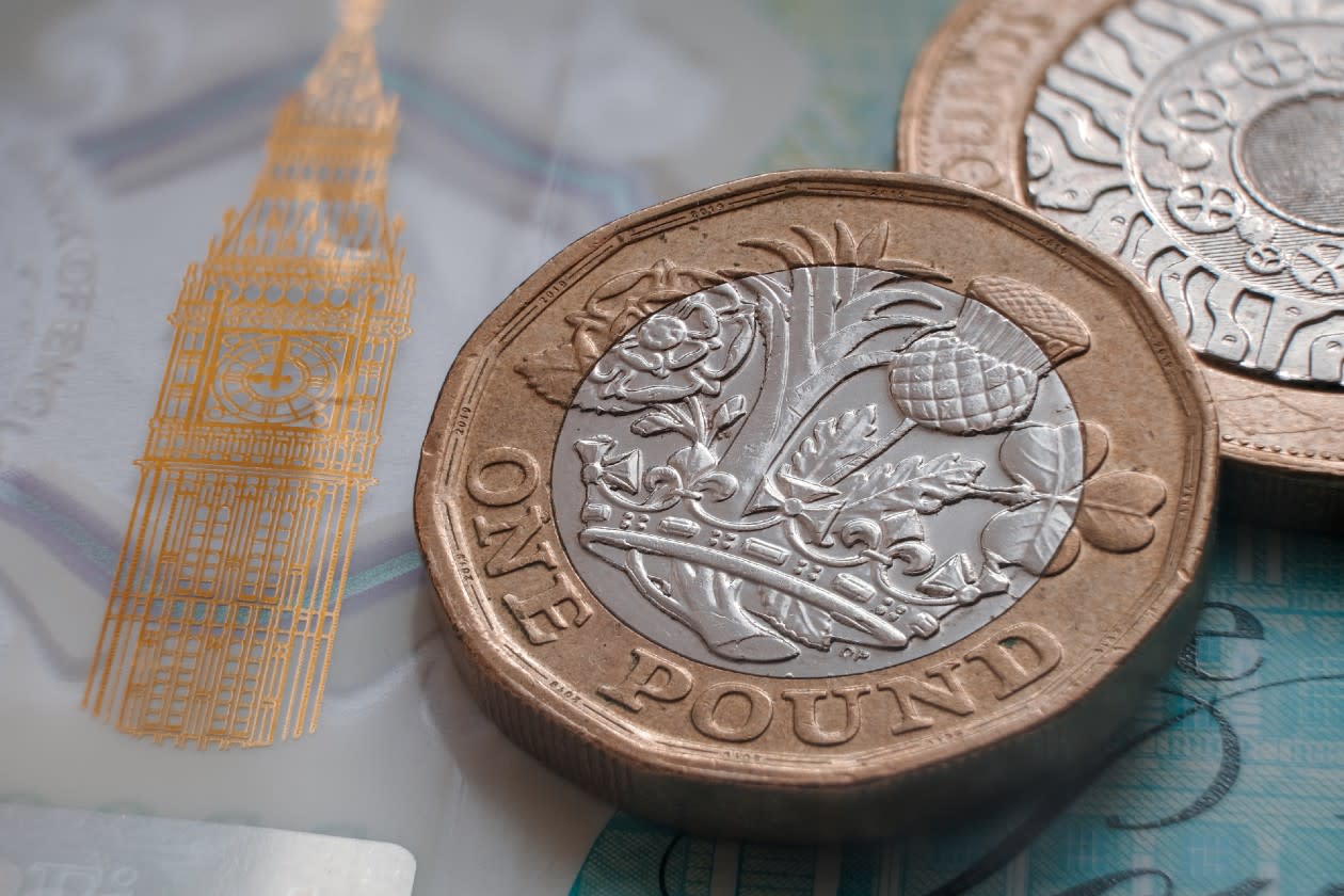 Pound coin on top of a UK banknote.jpg