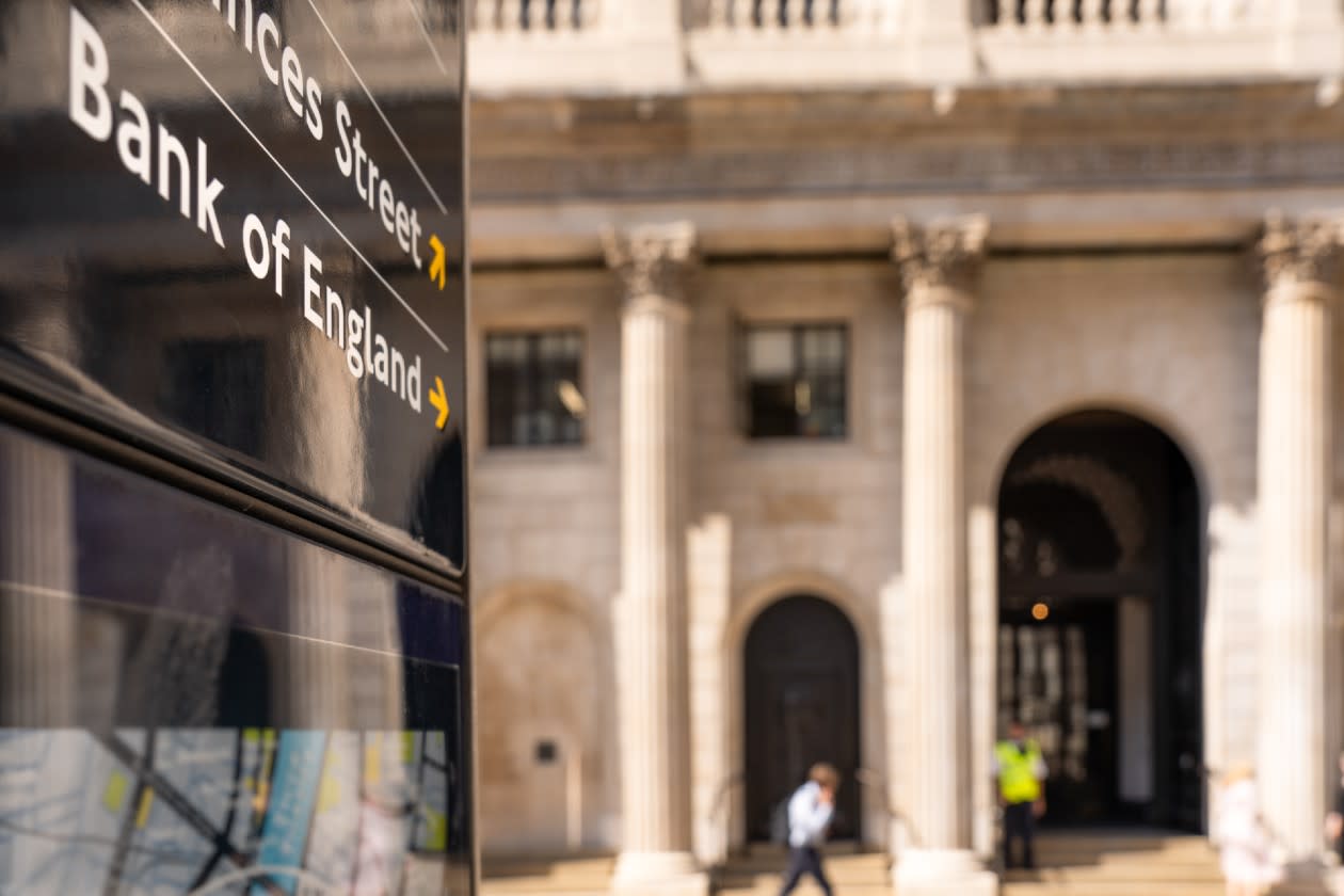 Close-up on a sign for the Bank of England with a pedestrian passing in the background.jpg