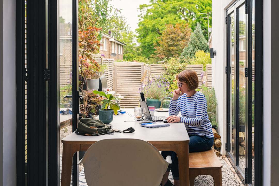 A view of a mature woman working from home from her back garden.jpg