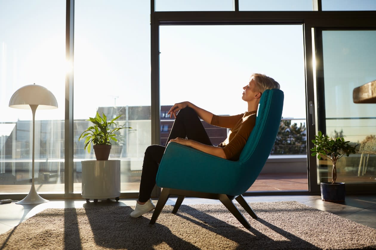 Woman relaxing in a chair in her apartment in the sunshine.jpg