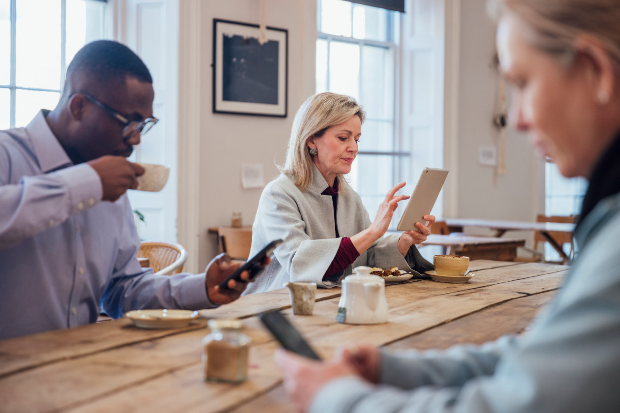 Businesswoman in a coffee shop using a smartphone and digital tablet in the city.jpg
