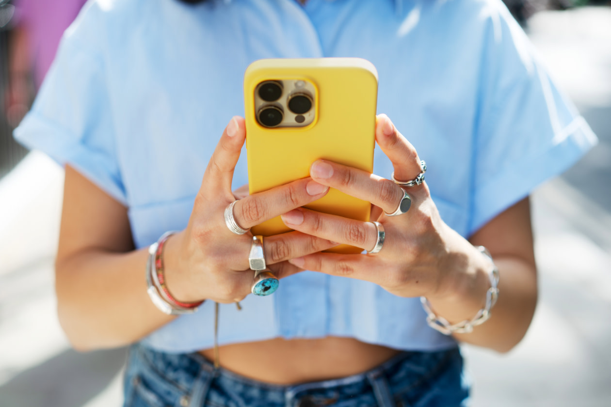 Apple - a woman looking at her phone outside.jpg