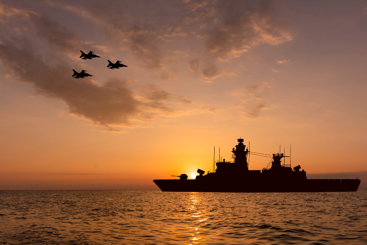 Warship and fighter jets at sunset.jpg