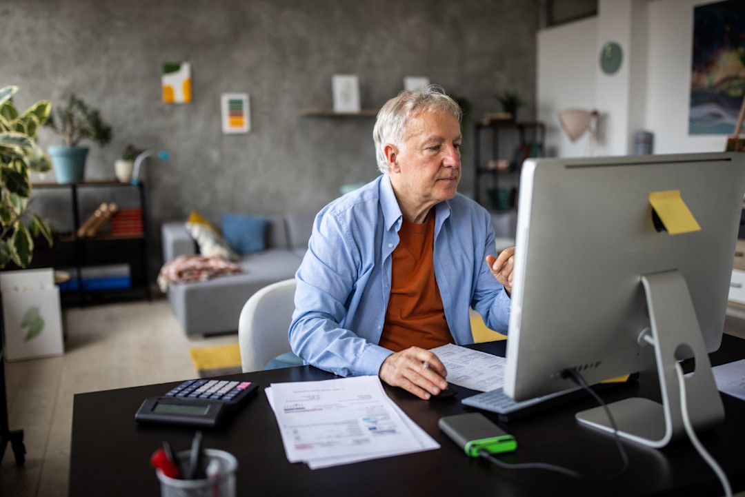 Senior male at computer in a spacious home office.jpg