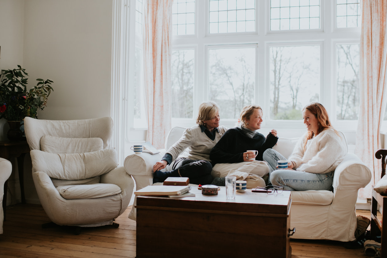 Three woman on a comfortable sofa enjoying a lighthearted discussion.jpg
