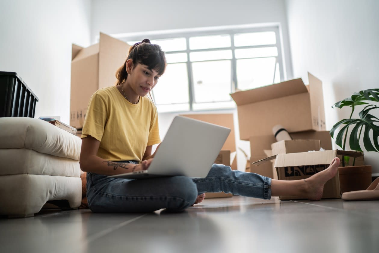 Young female first time buyer in her new property with boxes of belongings visible.jpg