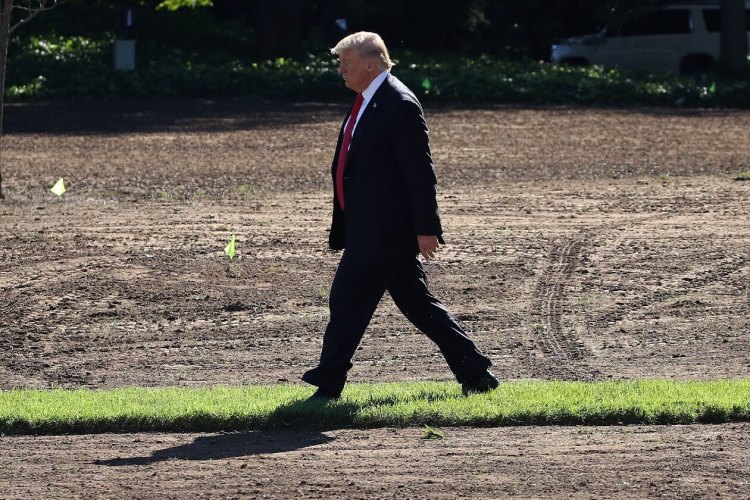 Donald Trump walking across a muddy field.jpg