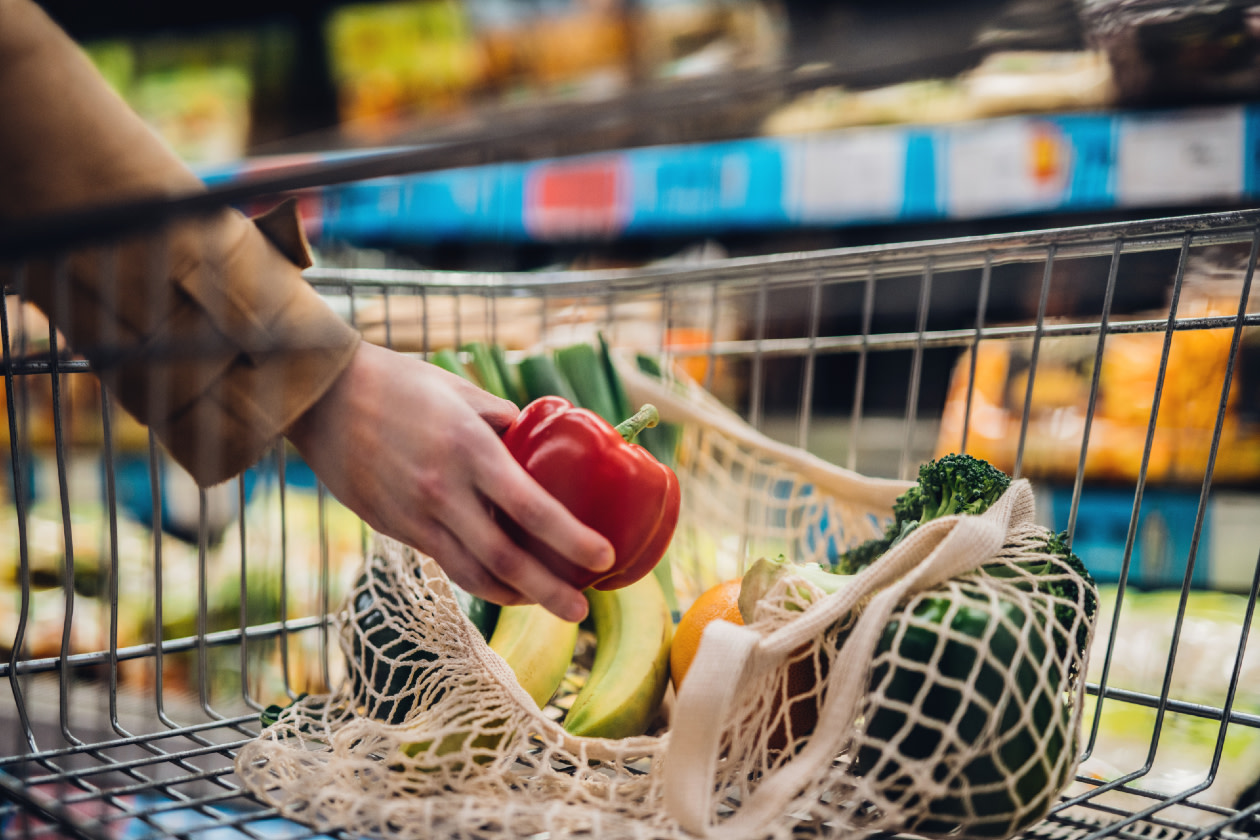 Grocery shopping with reusable shopping bag at supermarket- GettyImages
