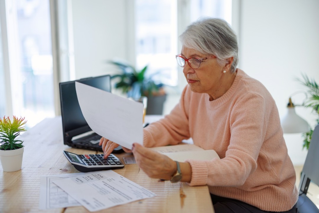 Female pensioner reviewing her finances at home.jpg