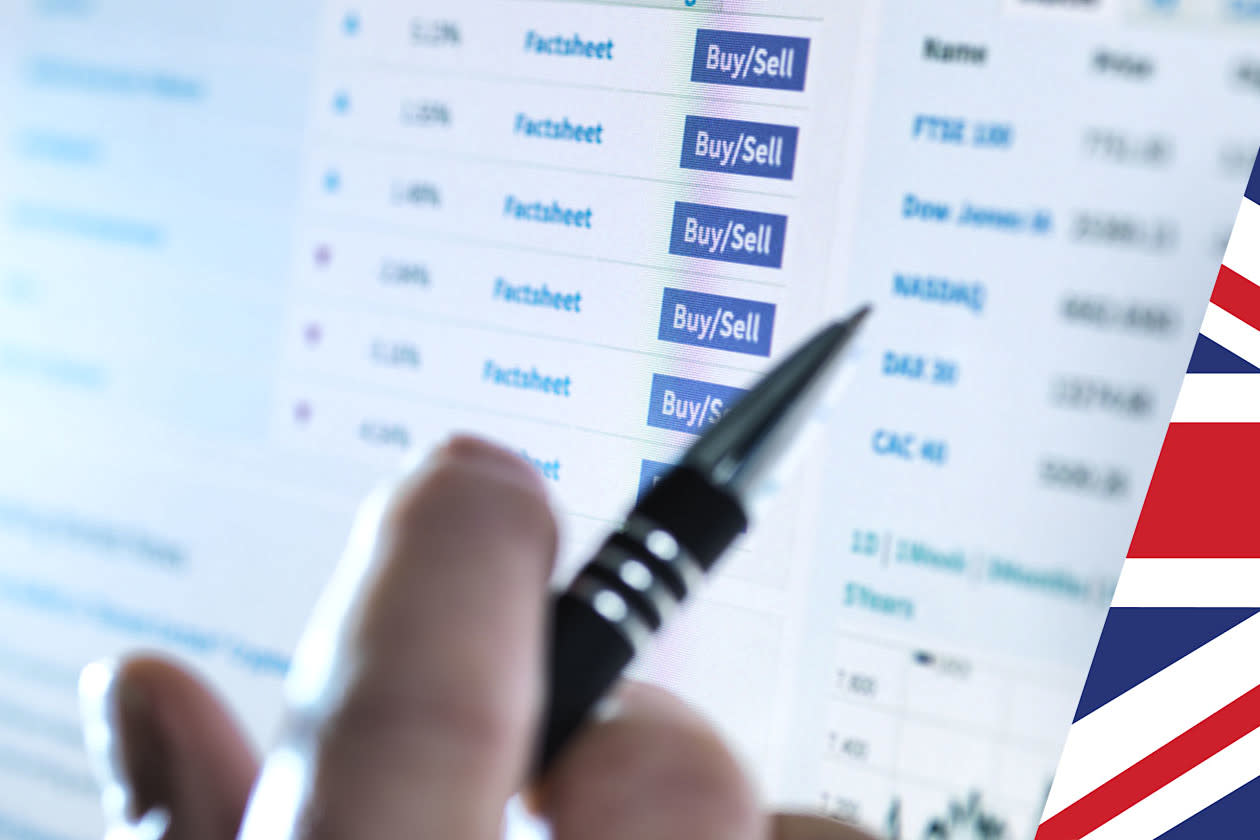 Hand of a stockbroker buying and selling shares online- Union jack overlay