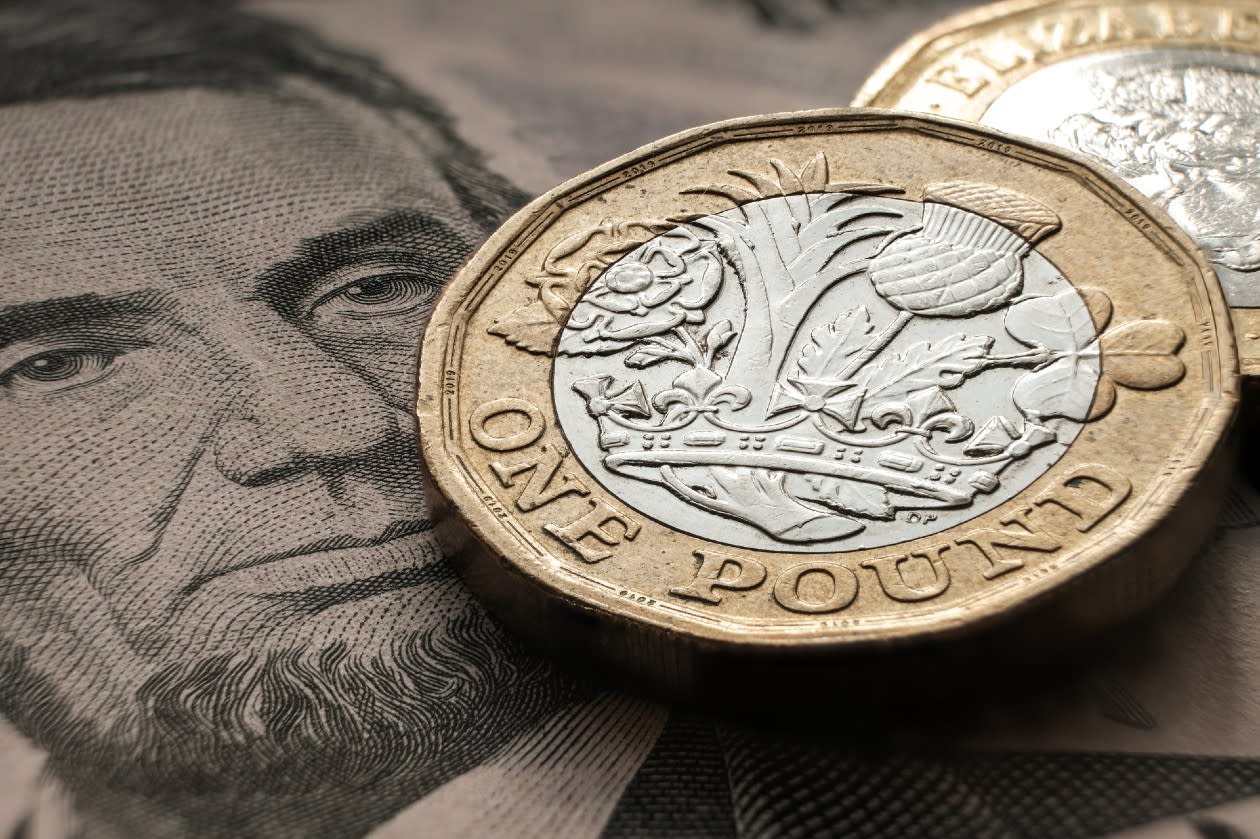 Closeup of a British Pound coin on top of a US dollar banknote.jpg