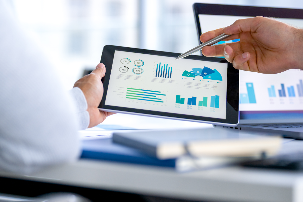 Two business men looking at financial graphs on a tablet.png