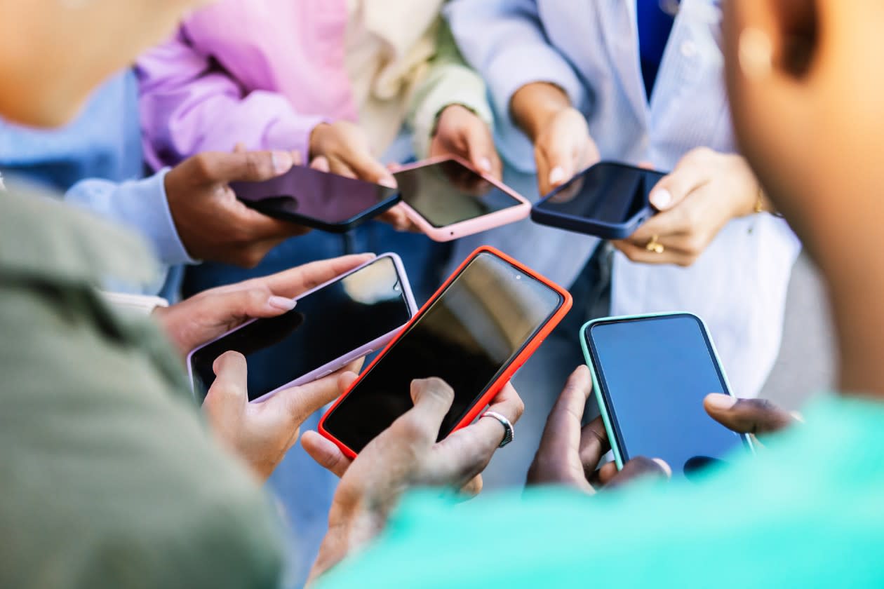 Group of friends in a circle using social media on their phones.jpg