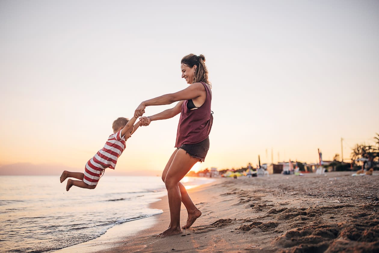 Mother and son playing on the beach by the sea.jpg