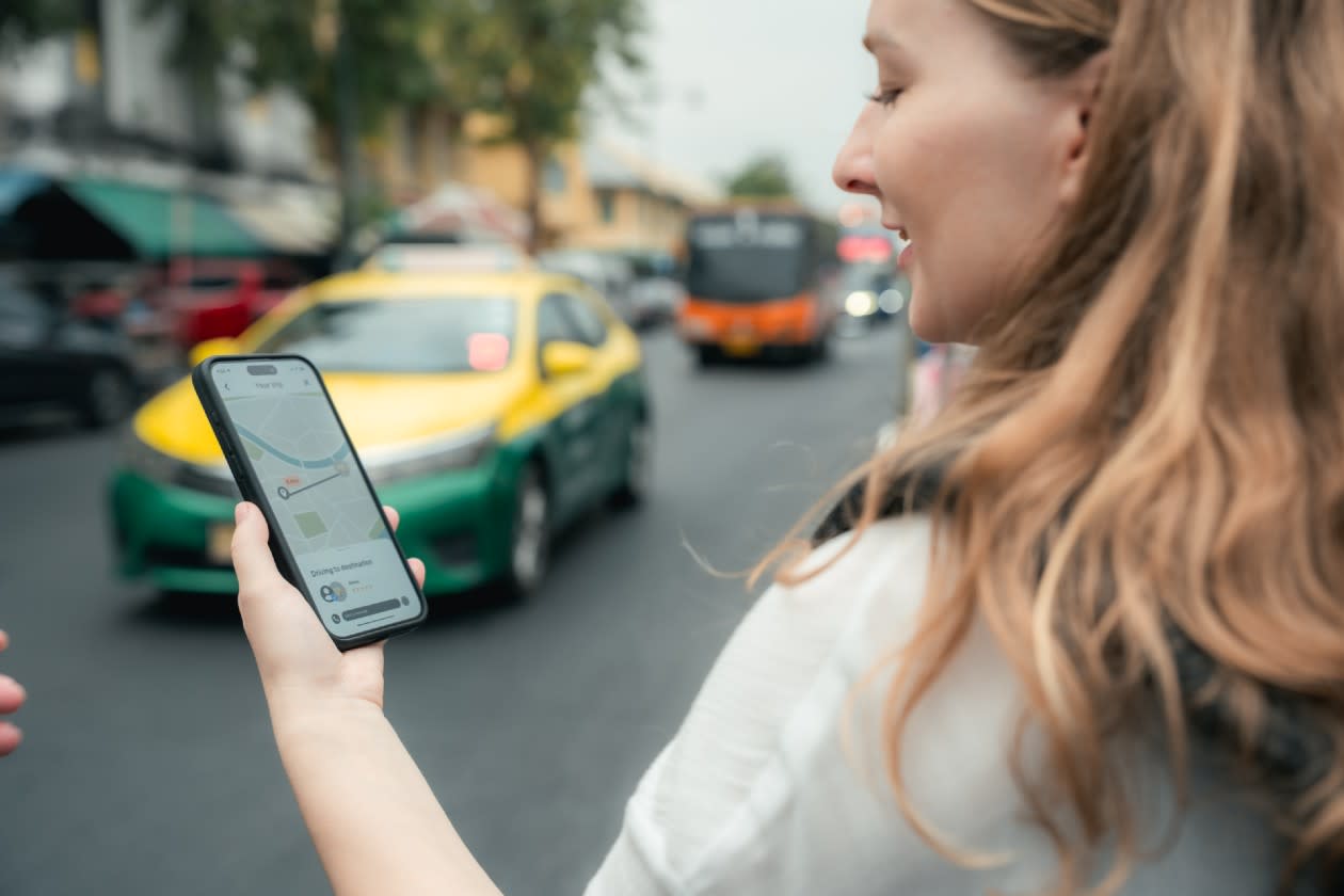 Woman hailing an Uber by a roadside