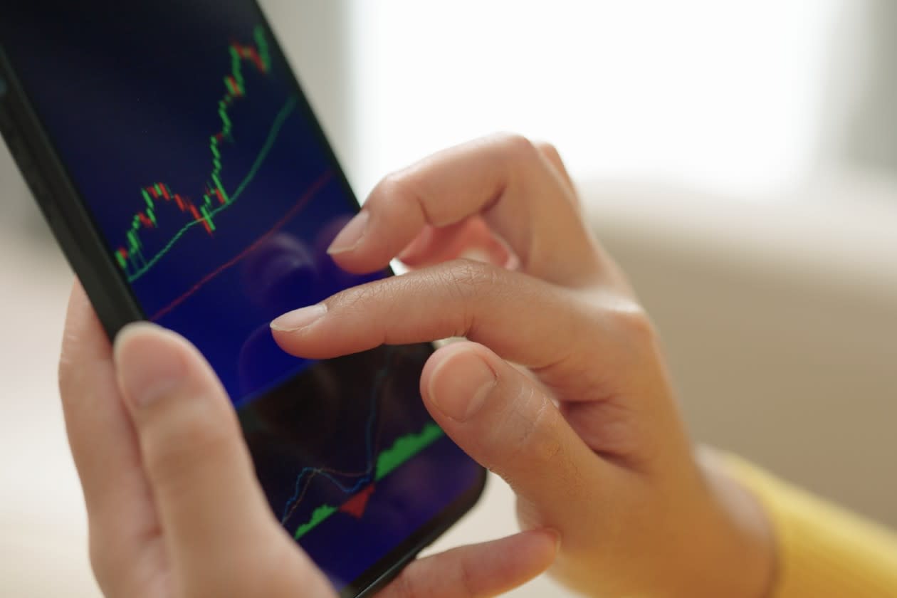Woman checking a stock market chart on her phone.jpg