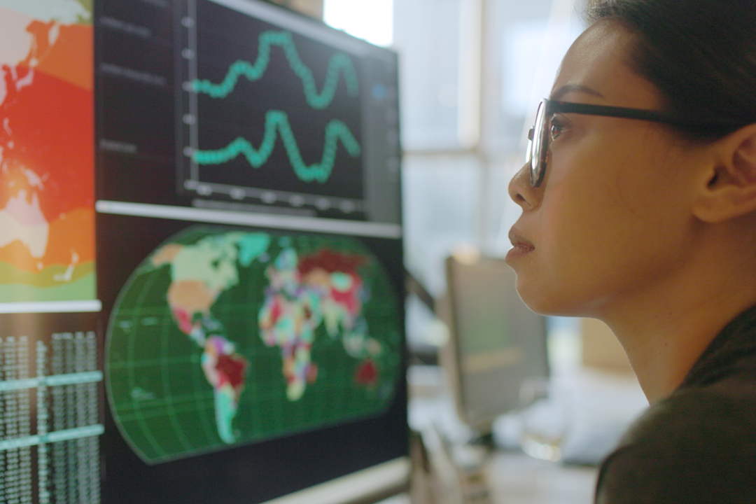 Woman looking at maps and stats on computer.png