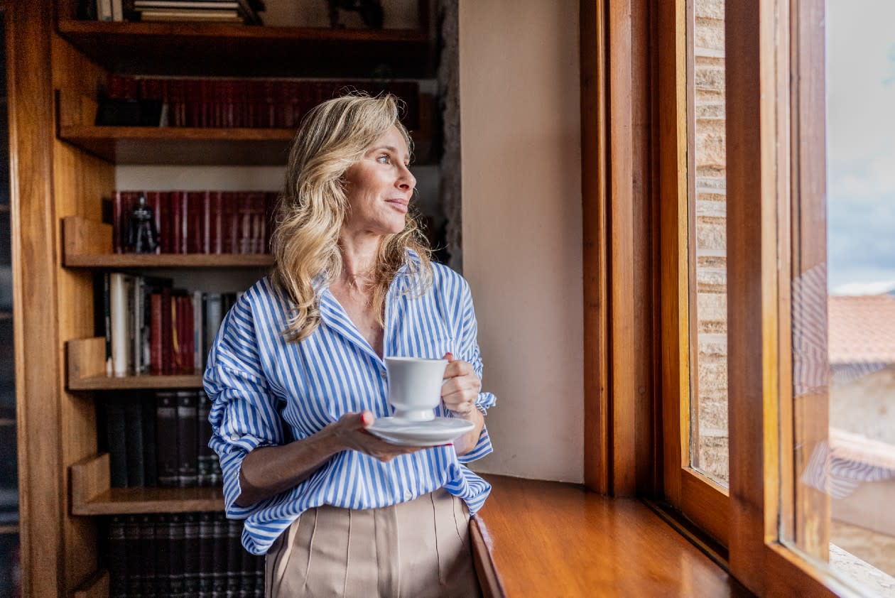 Mature female professional looking out of the window in her premium property.jpg