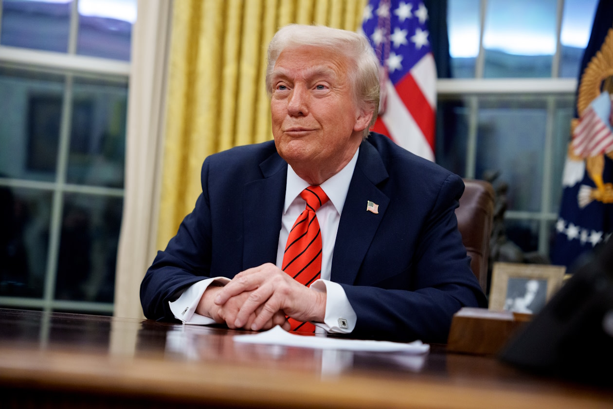 Trump smiling at his desk