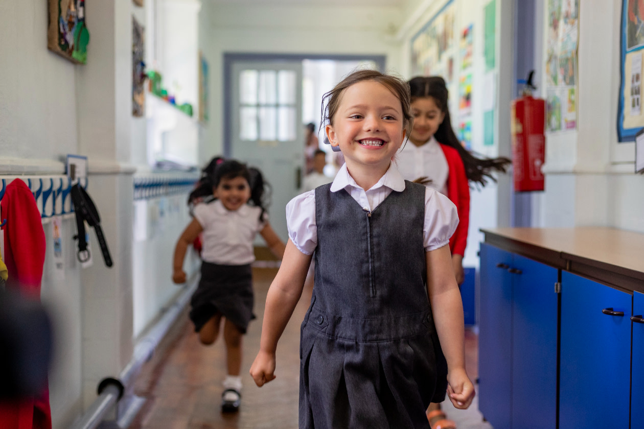 Primary school students running down a hallway at school in the North East of England- GettyImages