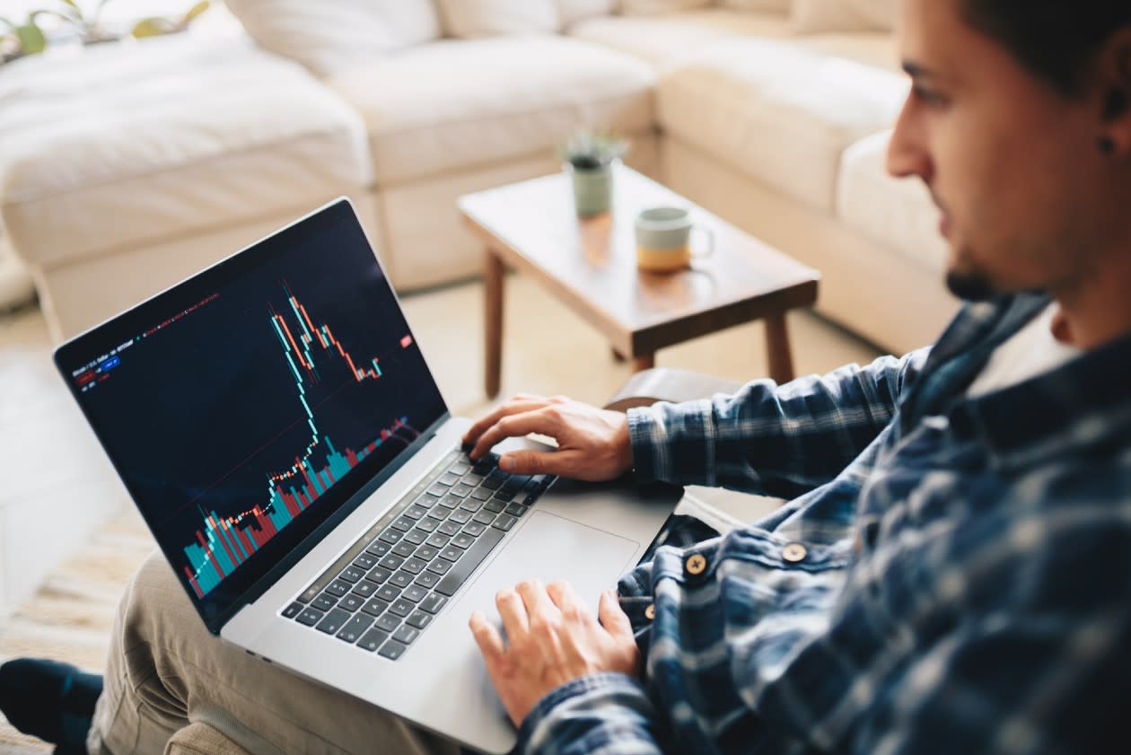 Man sitting relaxed in a chair viewing a chart on his laptop.jpg