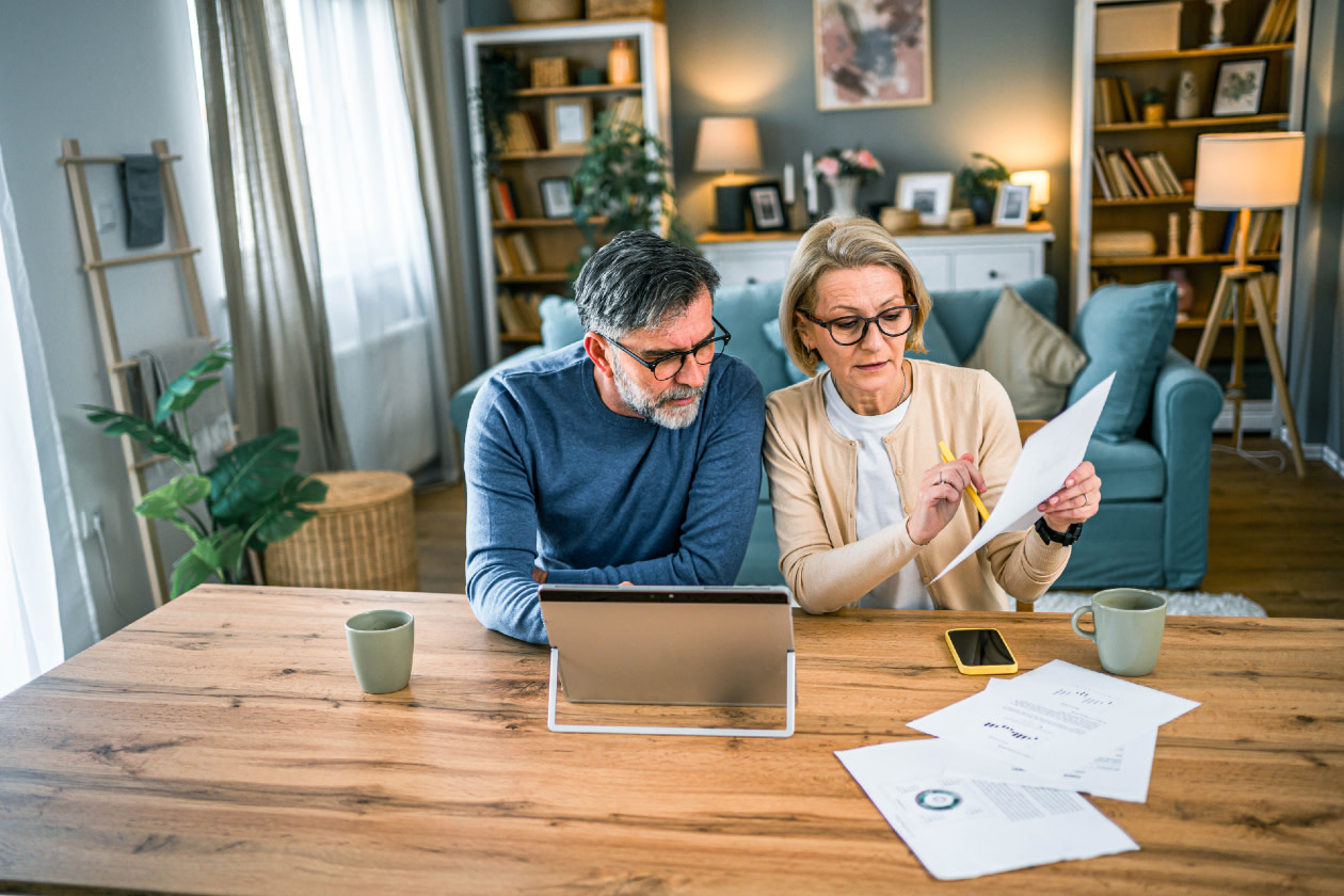 Mature couple manages expenses and bills together at home- GettyImages