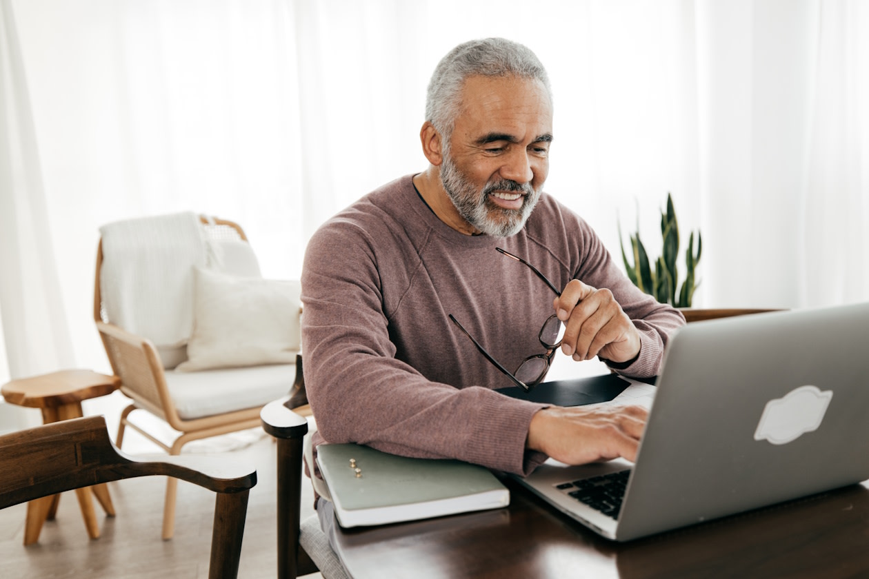 Man smiling whilst checking his pension.jpg