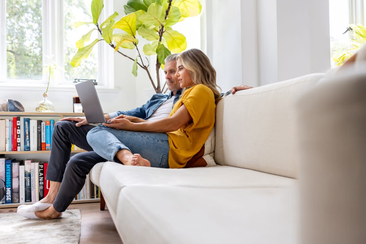 Couple doing research on their laptop together on the sofa.jpg