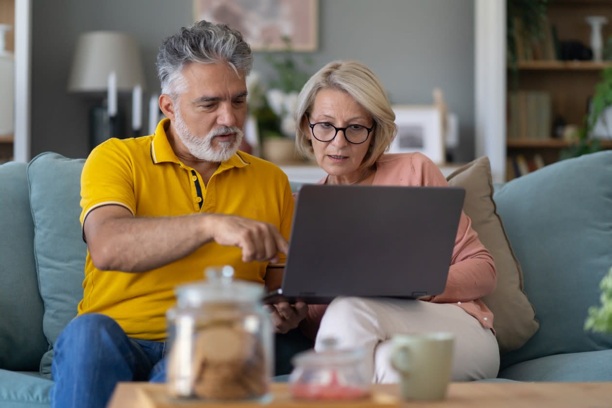 Couple sat on a sofa reviewing options together on a laptop.jpg