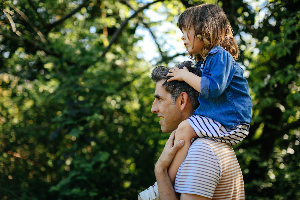 Father piggybacking little girl on nature walk.jpg