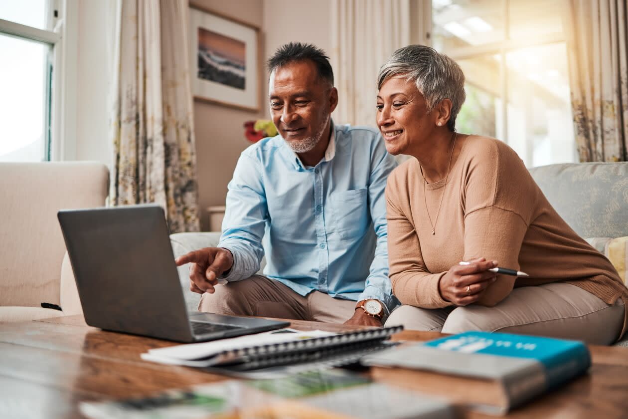 Mature couple, sofa and laptop for planning finance, retirement funding and investment or asset management at home.